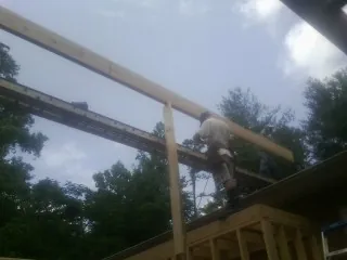 Carpenter setting a ridge beam over a new addition frame — Ice Dam Removal by Roofing Brothers in Kershaw