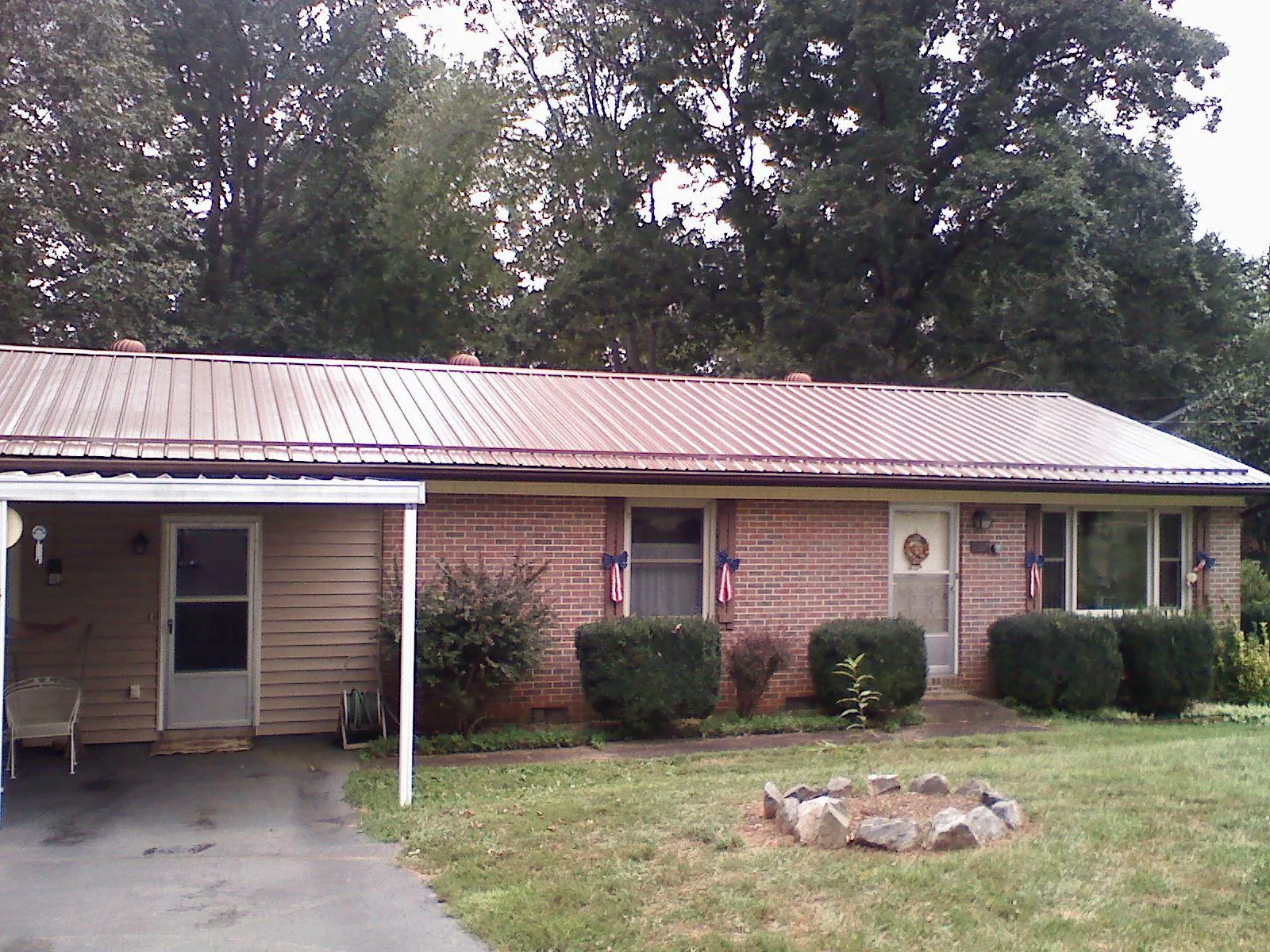 Bronze metal roof and carport on a brick ranch home — Roof Repair work by our crew in Kershaw